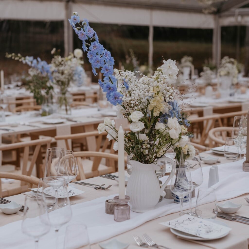 Tischdekoration mit Blumen in einem Eventzelt in NRW