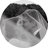 Hochzeitspaar küsst sich unter dem Schleier der Braut