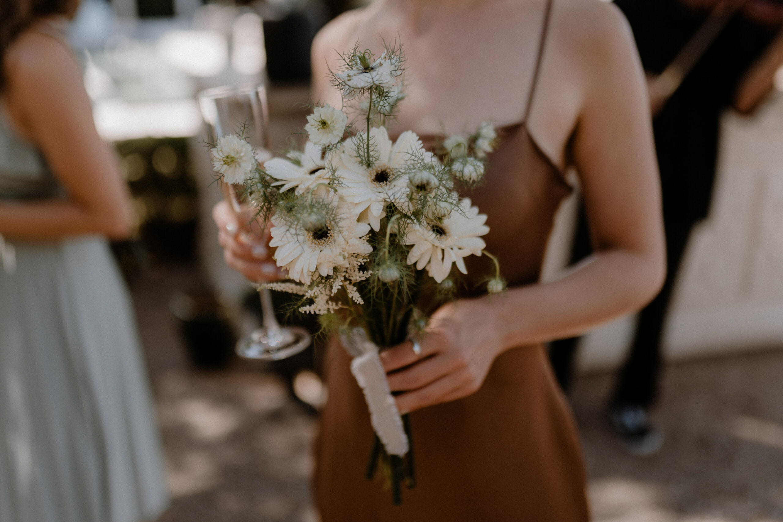 Eleganter Brautstrauß mit weißen Blumen in der Hand einer Brautjungfer bei einer Hochzeitsfeier in NRW.