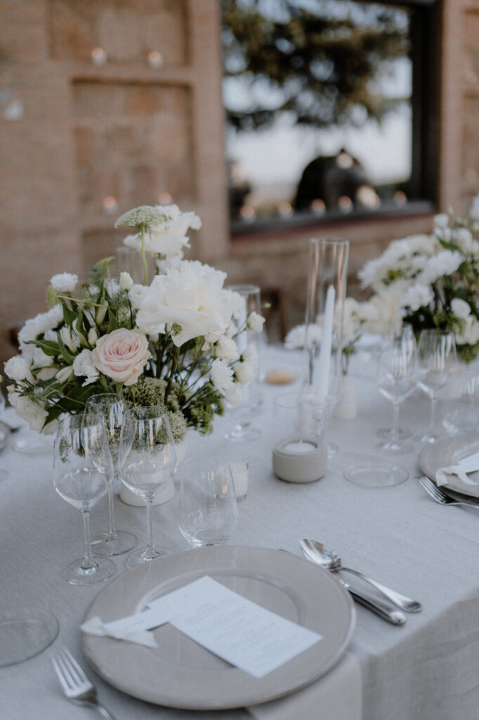 Detailansicht der Tischdekoration: Blumenstrauss, Kerzen, Gläser, Besteck und Teller