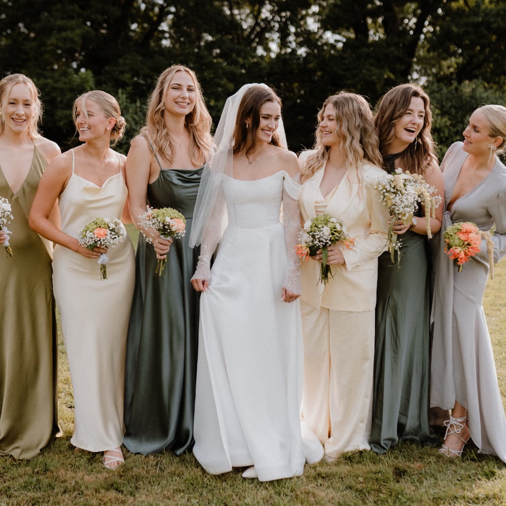 Braut mit Brautjungfern in stilvollen Kleidern bei einer sommerlichen Outdoor-Hochzeit in NRW – Hochzeitsplanung mit Liebe zum Detail.
