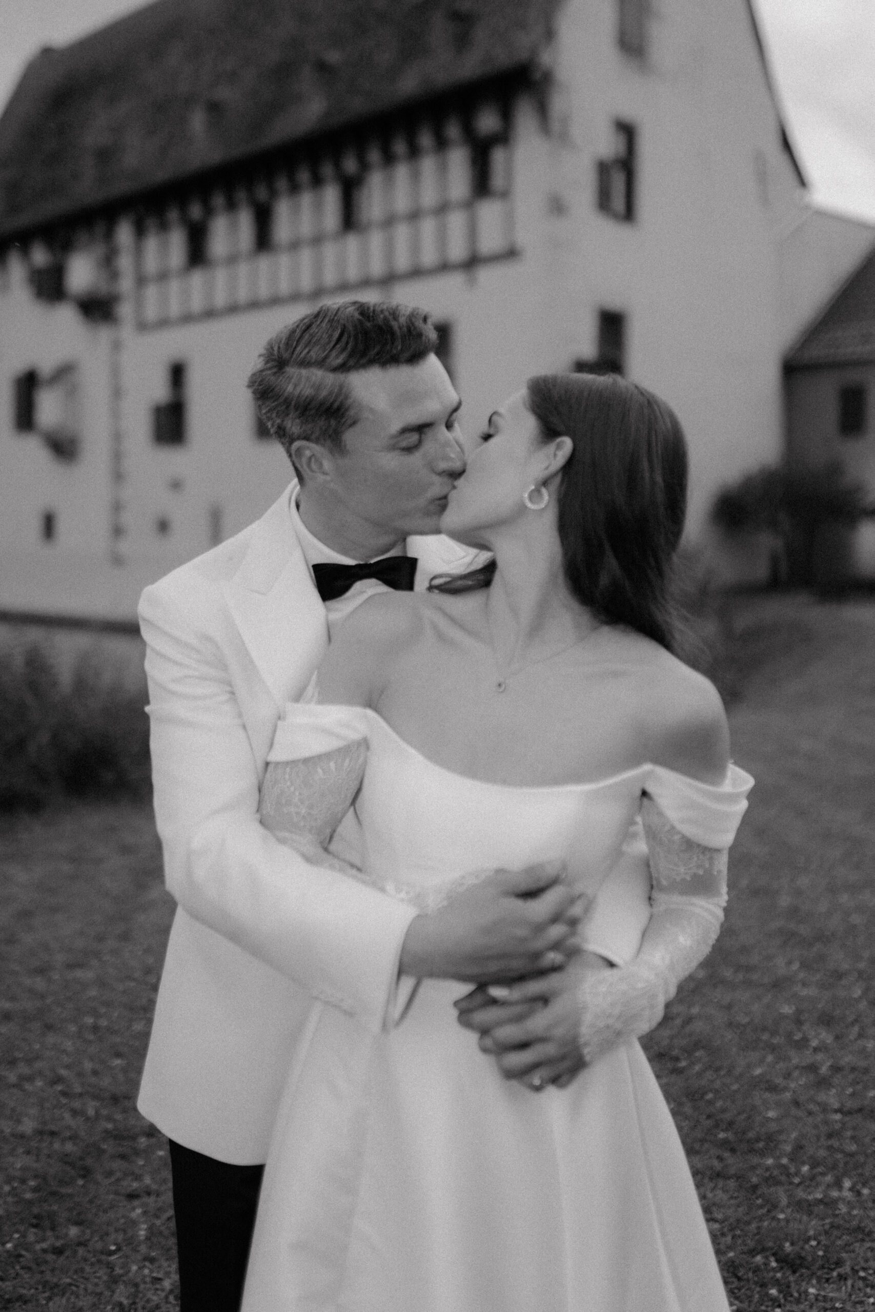 Intimer Kussmoment des Brautpaares vor Hochzeitslocation – romantische Hochzeitsplanung Düsseldorf